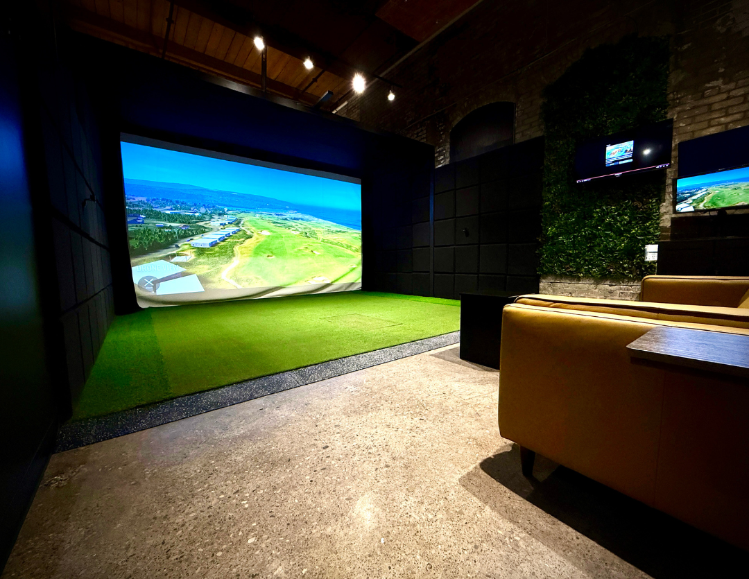 A bay with a wide projection screen and a brown leather banquette along the side wall.